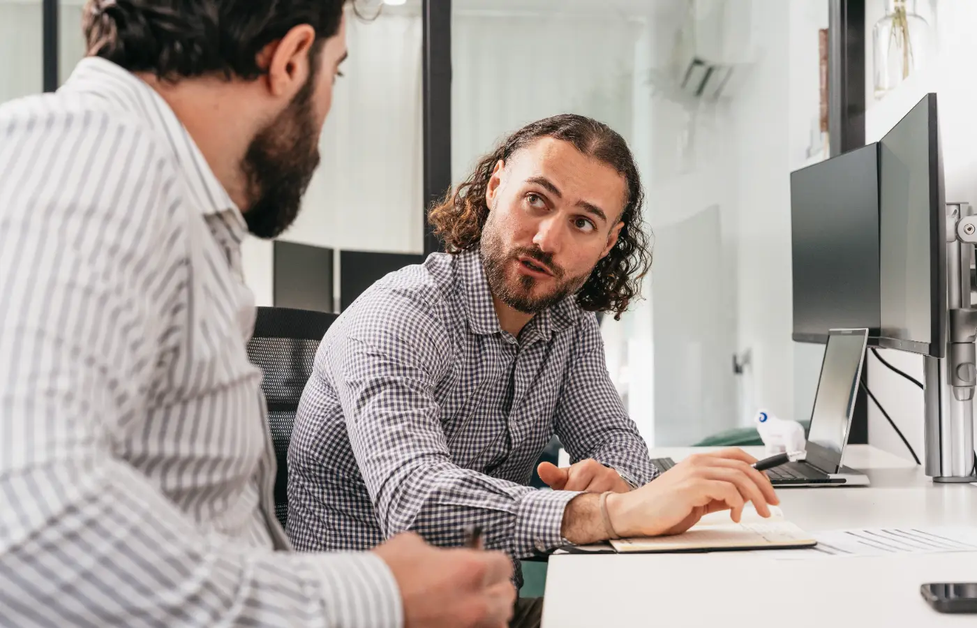 Two people at a desk working through something on screen together