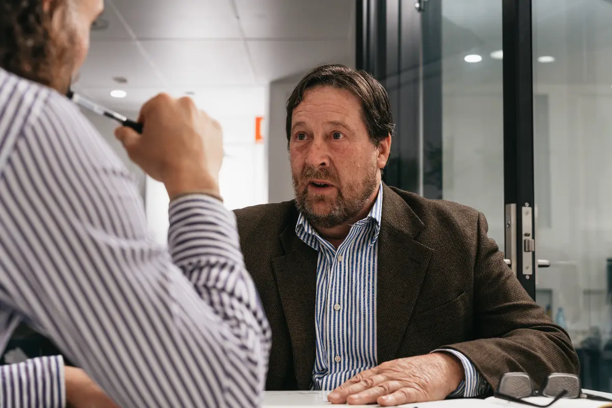 Two people mid-conversation across a meeting table